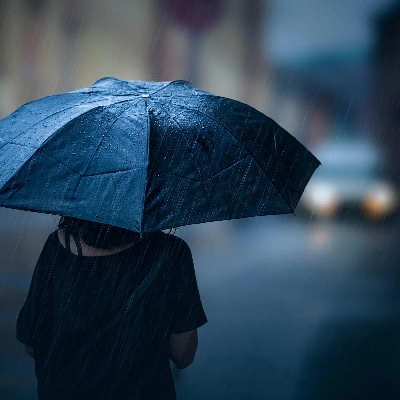 Image of person holding umbrella in storm