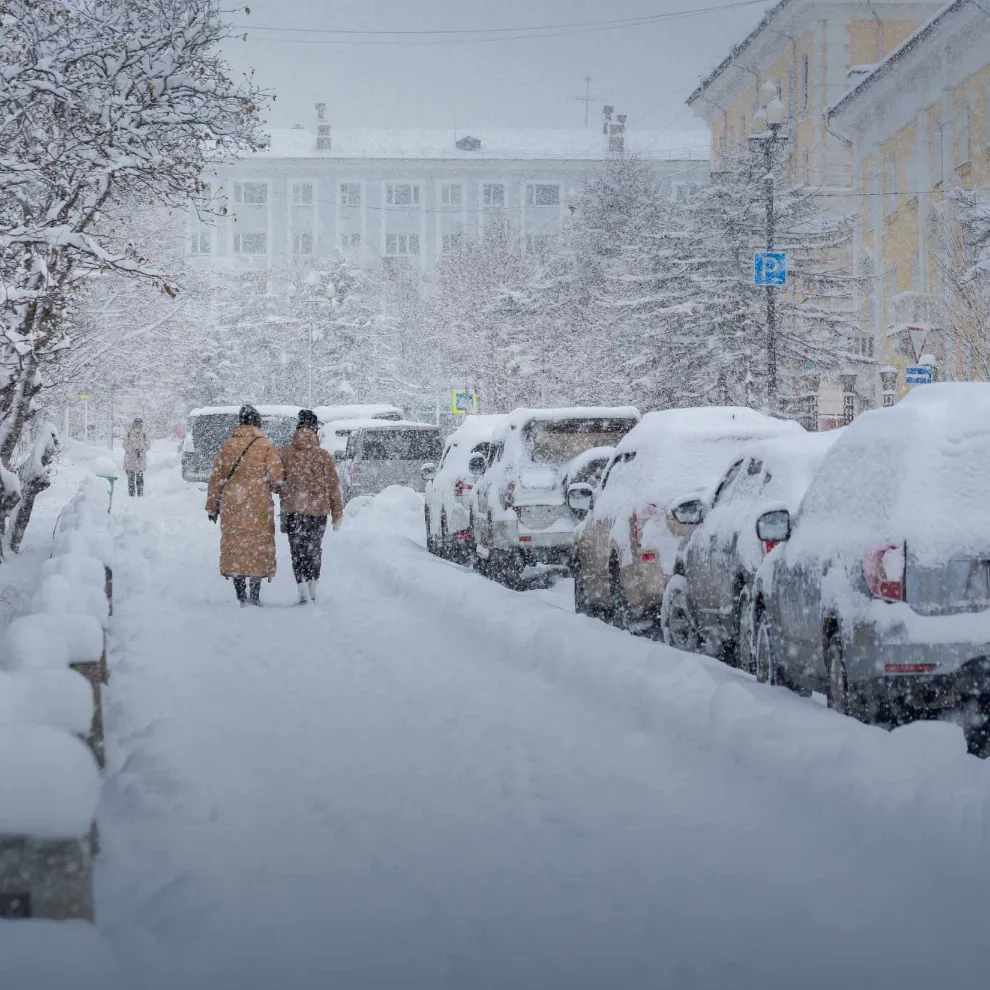 Image of two people walking on the street in a snow storm