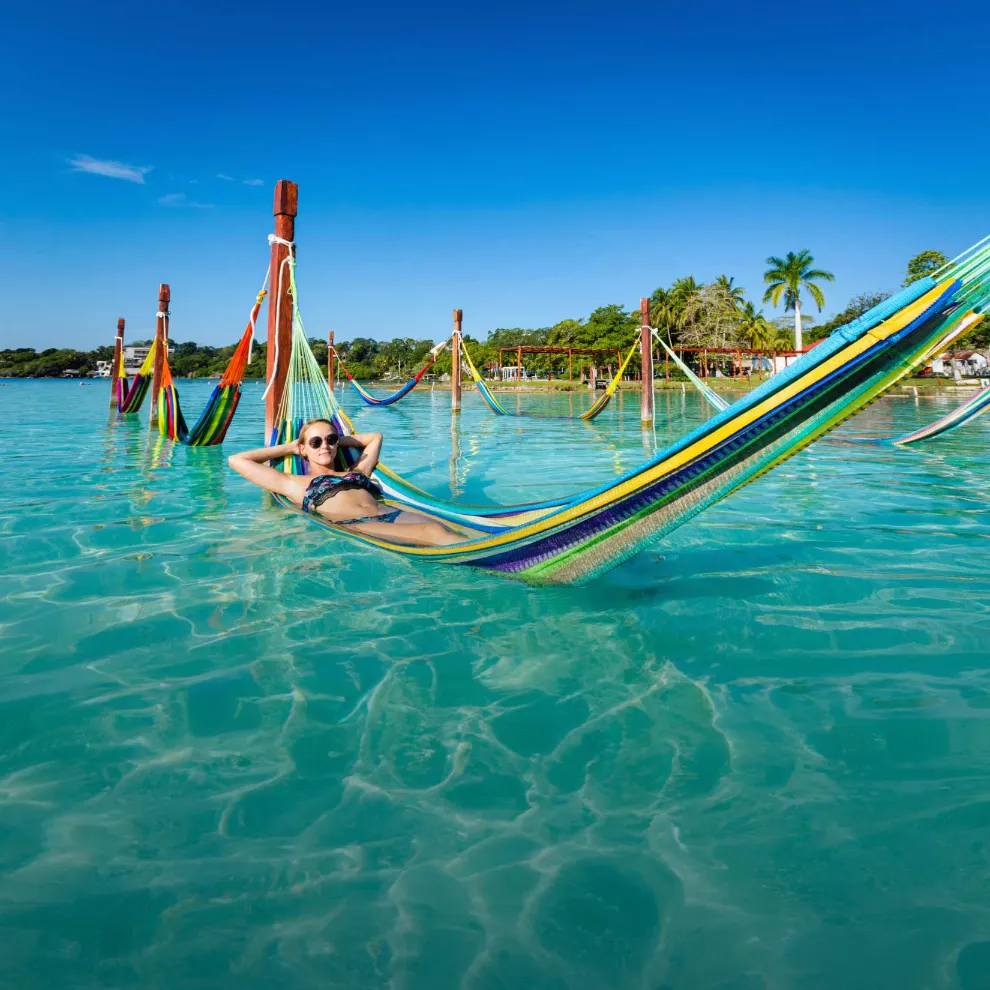 Image of woman in a water hammock in a tropical location